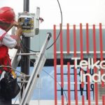 Seorang petugas dari PT Telkom sedang memperbaiki jaringan kabel