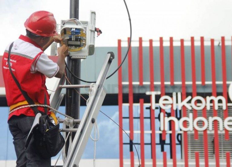 Seorang petugas dari PT Telkom sedang memperbaiki jaringan kabel