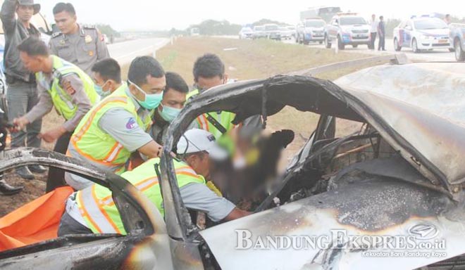 TERHIMPIT: Polisi dibantu TNI dan petugas Tol Cipali mengevakuasi penumpang yang tewas terpanggang setelah Gran Max meledak seketika di KM 178, Sumberjaya Kabupaten Majalengka, kemarin (6/7)