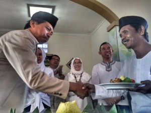 TUMPENG: Kepala SMPN 47 Bandung Drs Jamaludin M MPd menyerahkan tumpeng kepada ketua panitia temu alumni akbar, Suharto, disaksikan pengurus IKA, baru baru ini.