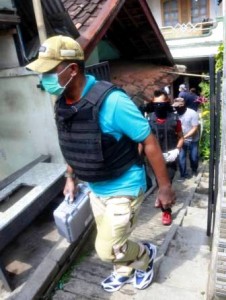 BAWA BUKTI: Anggota Densus 88 usai melakukan penggeledahan di salah satu rumah terduga bom Kampung Melayu.