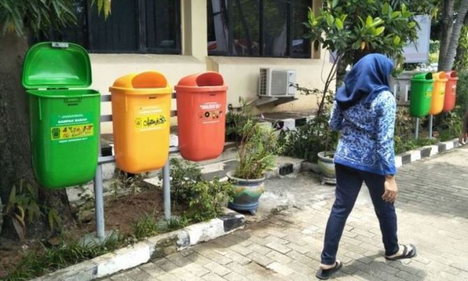 Seorang PNS berjalan di depan tempat pembuangan sampah tiga jenis di lingkungan perkantoran Pemkot Bandung.