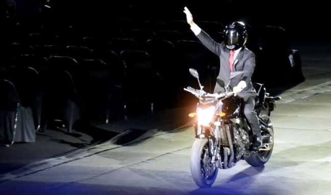 Presiden dengan mengendarai motor saat tiba di lokasi acara pembukaan Asian Games XVIII Tahun 2018