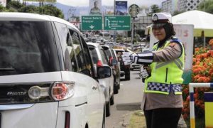 Petugas Polisi dari Polres Bogor sedang mengatur arus lalu lintas.