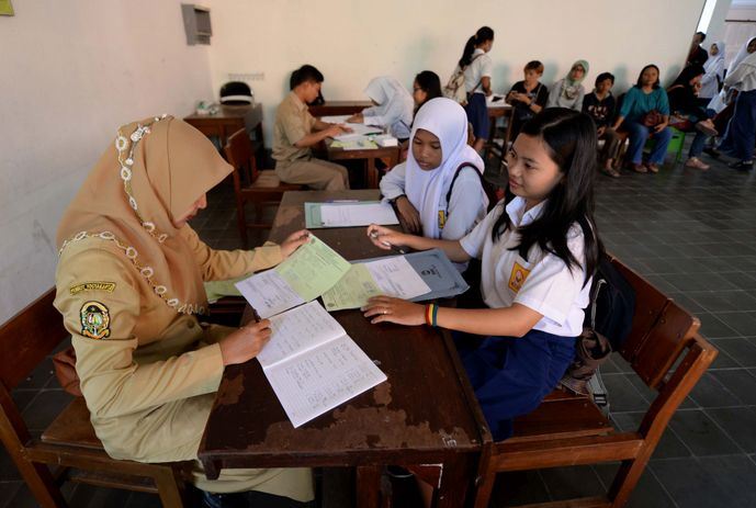 PERIKSA BERKAS: Seorang guru di salah satu SMAN Kota Bandung saat memeriksa berkas siswa yang mendaftar PPDB. (ist)