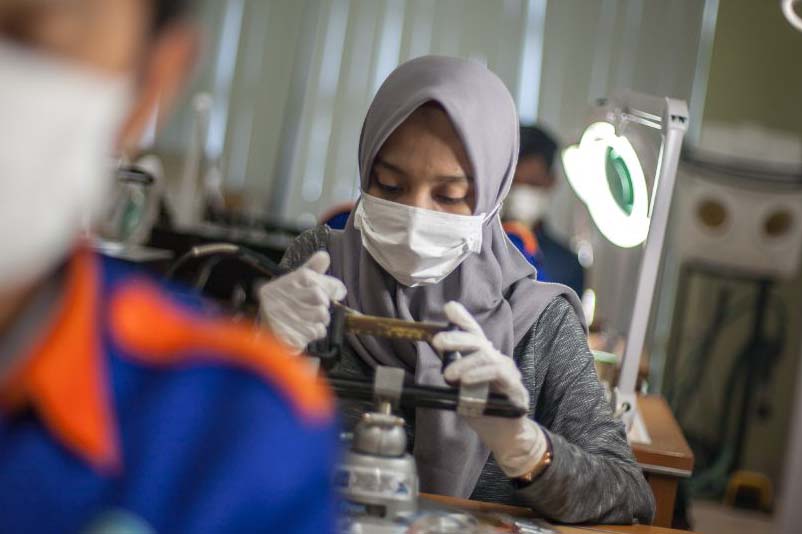 Seorang pekerja wanita di pabrik industri elektronik Cikarang Bekasi sedang fokus memasang komponen yang merupakan Produk Dalam Negara. (ILUSTRASI)