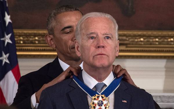Barack Obama mengalungkan medali kepada Joe Biden. Foto: AFP