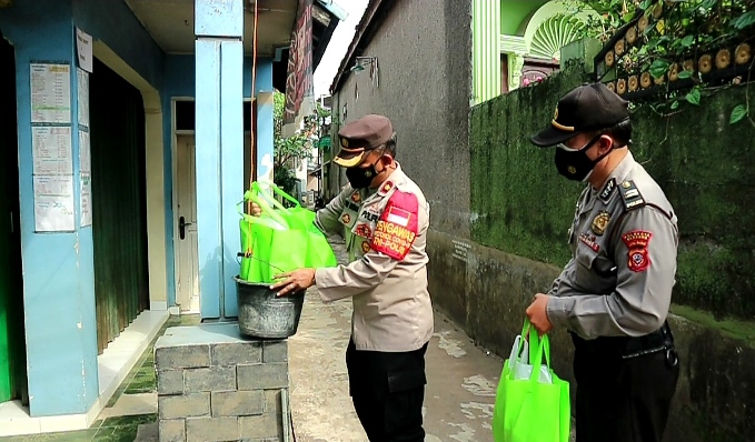 Kapolsek Dayeuhkolot Kompol Tedi Rusman memberikan sembako kepada satu keluarga yang terkonfirmasi Covid-19 di Desa Citereup Kabupaten Bandung.