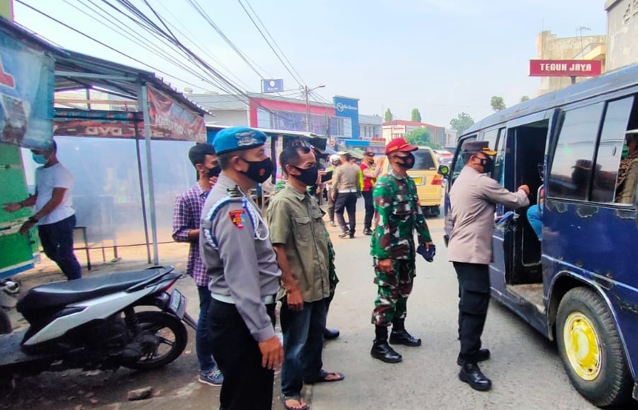 Polsek Dayeuhkolot bersama Koramil Dayeuhkolot membagikan masyarakat kepada para pengendara, di wilayah Kecamatan Dayeuhkolot, Kabupaten Bandung, Jumat (11/6).