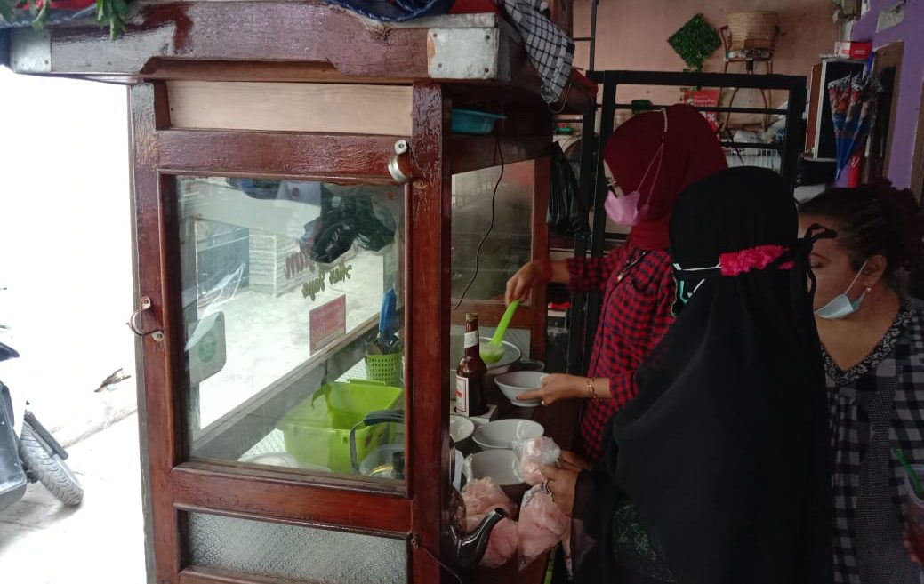 Istri Gufron ikut membantu melayani pemesanan Bubur ayam untuk diberikan kepada tetangga yang menjalani Isolasi Mandiri (Isoman) Foto: Sandi Nugraha/ Jabarekspres.