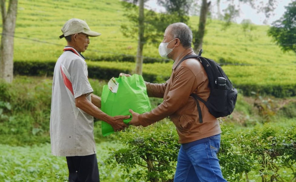 Seorang ASN dari Dinas Pemberdayaan Masyarakat Desa (DPM Desa) memberikan paket sembako kepada warga desa yang ditemuinya langsung di pelosok daerah