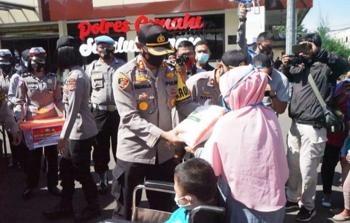 Kapolres Cimahi, AKBP Indra Setiawan membagikan paket sembako pada salah satu warga di Mapolres Cimahi, Minggu (11/7).