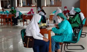 Siswi SMPN 1 Cimahi melewati tahapan screening sebelum vaksinasi. Foto: Intan Aida