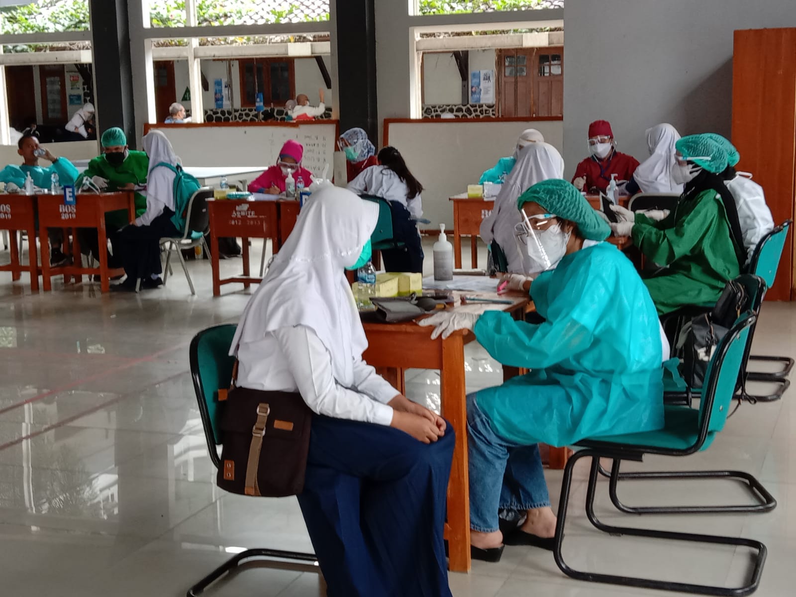 Siswi SMPN 1 Cimahi melewati tahapan screening sebelum vaksinasi. Foto: Intan Aida