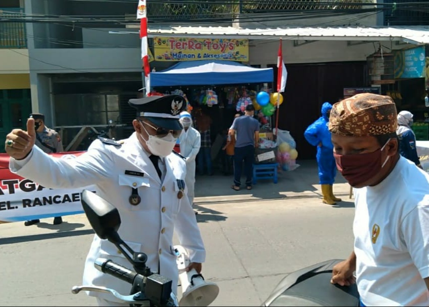 Lurah Rancaekek Kencana, Irwan Hardiansyah (kiri) usai berikan masker sekaligus edukasi prokes kepada warga yang tidak memakai masker, Selasa (17/8). (Yanuar Baswata/Jabar Ekspres)