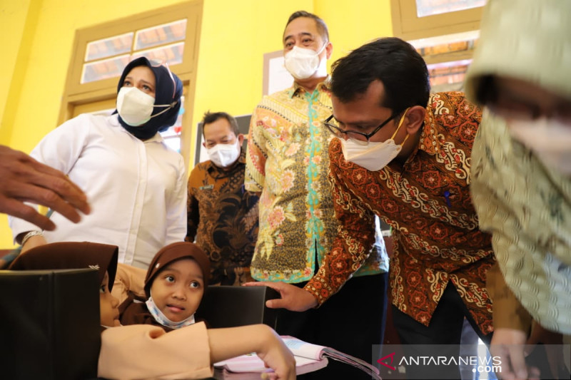 Wakil Bupati Garut Helmi Budiman berbincang dengan siswi kembar Siam di sekolahnya SDN 1 Tegalpanjang, Kecamatan Sucinaraja, Kabupaten Garut, Jawa Barat, Jumat (27/8/2021). (FOTO ANTARA/HO-Diskominfo Garut)