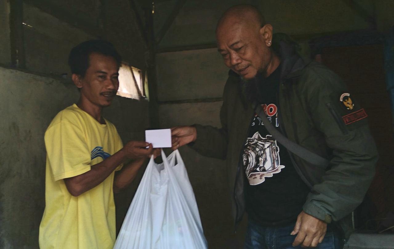 Jurnalis saat memberikan bantuan kepada korban longsor Sumedang, Rismana, 33, di kediamannya pada Rabu (4/8).