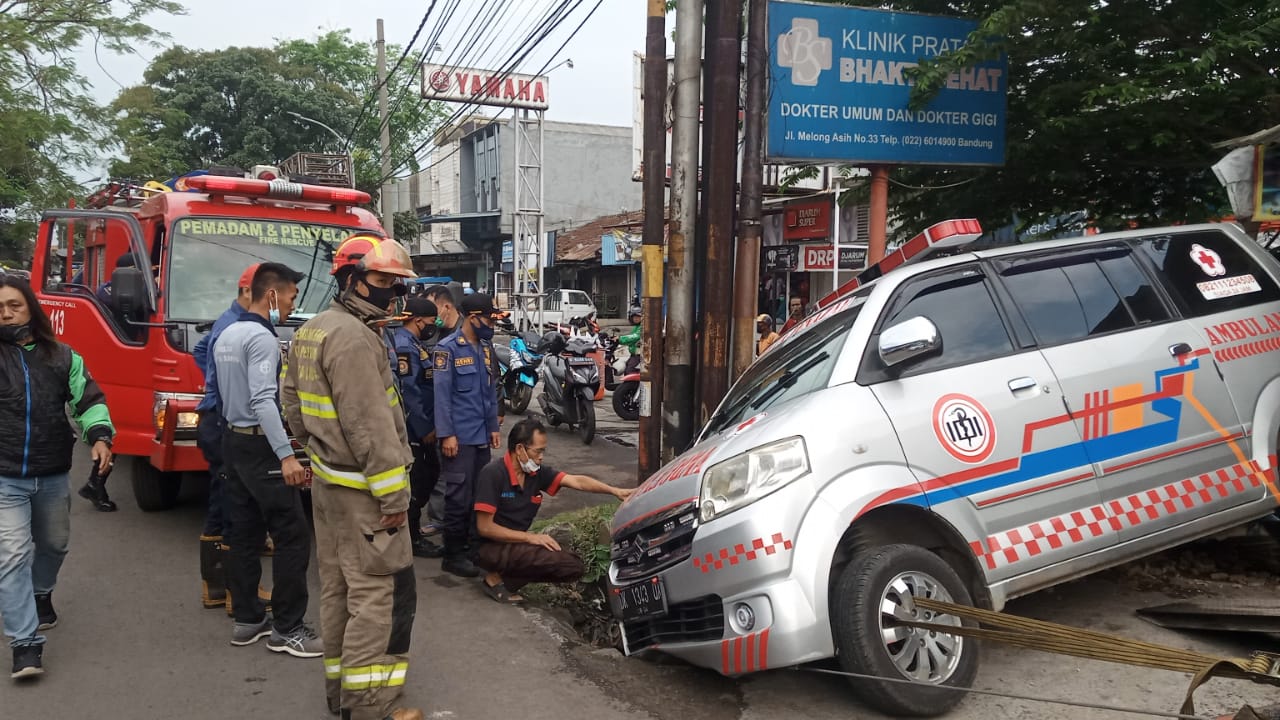 Sebuah mobil ambulans tergelincir pada lubang besar pada trotoar jalanan, Kamis (5/8).