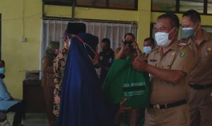 Camat Cikancung, Maksum (kanan) saat berikan bantuan paket sembako kepada warga di aula Kecamatan Cikancung, Kabupaten Bandung pada Selasa (24/8). (Yanuar Baswata/Jabar Ekspres)