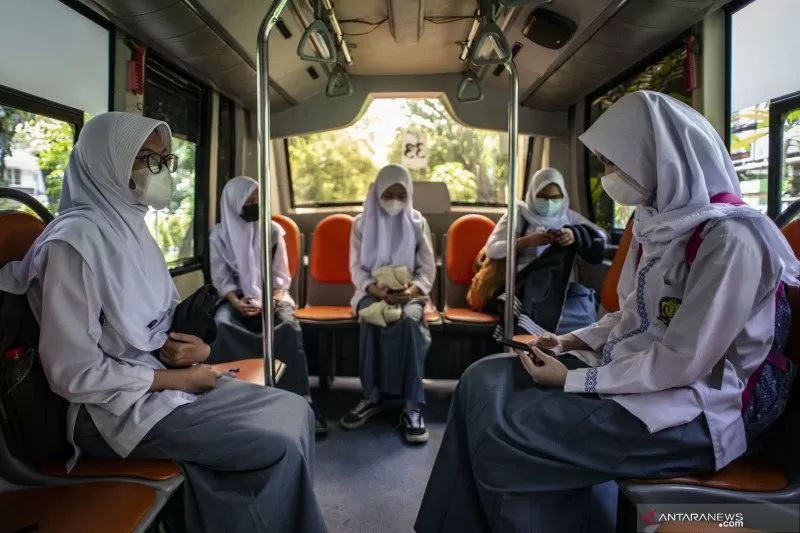 Pelajar SMKN 15 Jakarta menaiki Bus Sekolah Gratis seusai mengikuti uji coba pembelajaran tatap muka di SMKN 15 Jakarta, Kebayoran Baru, Jakarta Selatan, Jumat (9/4/2021). ANTARA FOTO/Aprillio Akbar/aww.