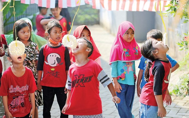 Sejumlah anak berpartisipasi dalam lomba makan kerupuk yang diselenggarakan oleh dan untuk kalangan keluarga sendiri di Bekasi. (IMAM HUSEIN/JAWA POS)