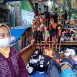 TERMENUNG - Enah menanti pengunjung yang biasanya datang untuk membeli dagangannya. Kini pendapatannya turun drastis, terdampak pandemi. Foto: Boy Darmawan, Jabar Ekspres