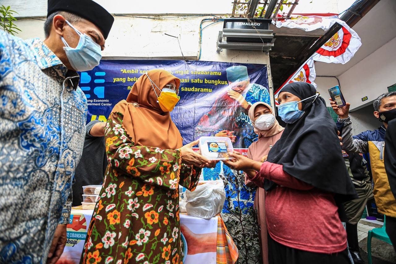 Wali Kota Bandung Oded M Danial dan Siti Muntamah sedang membagikan boks nasi kepada warga. (Foto: Humas Kota Bandung)