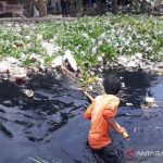 Warga membersihkan sampah di aliran Sungai Cilemahabang di Desa Sukakarya, Kecamatan Karangbahagia, Senin. (ANTARA/Pradita Kurniawan Syah).