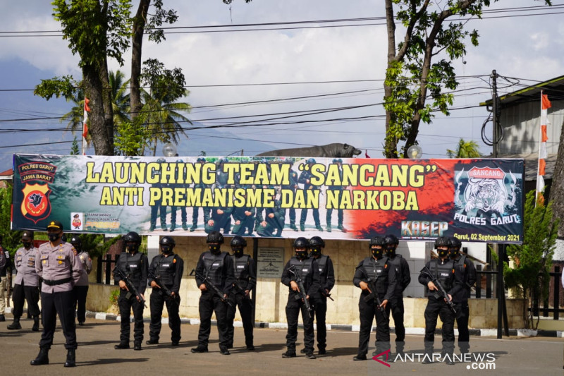 Bupati Garut Rudy Gunawan (kiri) memasangkan helm kepada anggota Tim Sancang saat Peluncuran Tim Sancang untuk memberantas premanisme dan narkoba di Markas Polres Garut