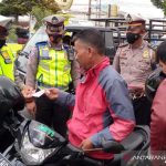 Sejumlah personel polisi membagikan masker kepada pengendara sepeda motor di Jalan Bunderan Suci, Kabupaten Garut, Jawa Barat, Senin (20/9/2021). (ANTARA/Feri Purnama)