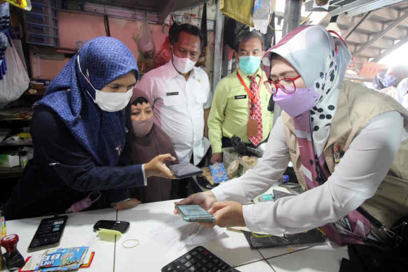 Petugas saat memberikan sosialisasi terkait pembayaran retribusi pasar secara nontunai di Cirebon, Jawa Barat, Rabu (22/9/2021). (ANTARA/HO Humas Pemkab Cirebon)