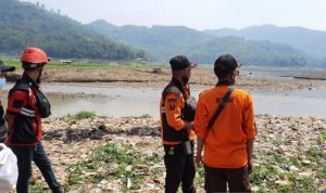 Relawan Tangguh Bencana (Retana) Cianjur, Jawa Barat, menyusuri pinggiran waduk Jangari guna menemukan tubuh pemancing yang hilang tenggelam, Minggu (5/9). (ANTARA/Ahmad Fikri)