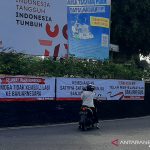 Seorang warga memotret spanduk yang terpasang di sekitar Alun-Alun Banjarnegara, Sabtu (4/9/2021), salah satunya bertuliskan ucapan terima kasih kepada KPK. (ANTARA/Sumarwoto)