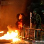 Arsip--Tentara Israel berdiri di samping pembakaran ban saat warga Palestina mengambil bagian dalam protes anti-Israel atas ketegangan di Yerusalem, di Hebron di Tepi Barat yang diduduki Israel, Senin (26/4/2021). ANTARA FOTO/REUTERS/Mussa Qawasma/AWW/sa.