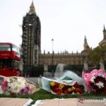 Bunga penghormatan diletakkan di depan Gedung Parlemen di London, Inggris, Sabtu (16/10/2021), setelah anggota parlemen Inggris David Amess ditusuk hingga tewas saat bertemu dengan konstituen. REUTERS/Henry Nicholls/FOC/djo.