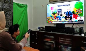 Seorang remaja menyaksikan siaran televisi didampingi orang tua. Siaran TV Digital hadir membawa beragam fitur diantaranya Parental Lock. (Foto: Ilustrasi)