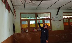 Kepala Sekolah SDN Kresna menunjukan flafon dan atap sekolah yang ambruk