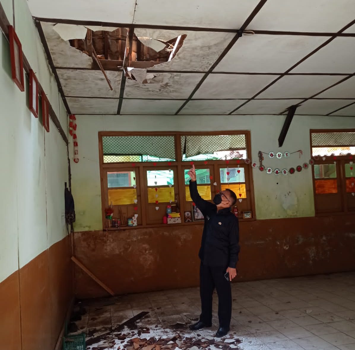 Kepala Sekolah SDN Kresna menunjukan flafon dan atap sekolah yang ambruk