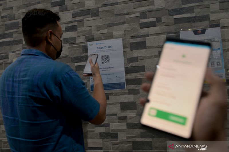 Pengunjung memindai kode batang (QR code) aplikasi PeduliLindungi sebelum memasuki pusat perbelanjaan di Manado, Sulawesi Utara, Jumat (1/10/2021). (ANTARA FOTO/ADWIT B PRAMONO)