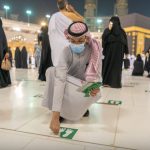 Petugas di Masjidil Haram Makkah membuka tanda stiker jaga jarak bagi para jamaah
