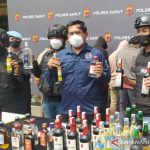 Polisi menunjukkan barang bukti minuman keras dan penjual hasil operasi pemberantasan minuman keras di Kabupaten Garut, Jawa Barat, Selasa (12/10/2021). (ANTARA/Feri Purnama)