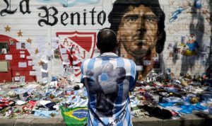 Seorang pria memandangi gambar legenda sepak bola Diego Armando Maradona sambil berduka atas kematiannya di depan stadion yang mengambil namanya di Buenos Aires, Argentina, Jumat (27/11/2020). ANTARA FOTO/REUTERS/Ricardo Moraes/HP/djo (REUTERS/RICARDO MORAES)