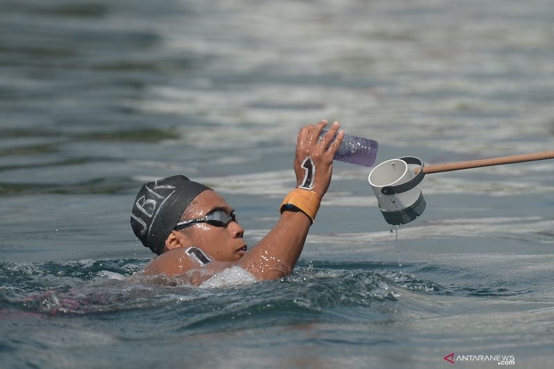Aflah Fadlan Prawira meminum air saat bertanding di final renang perairan terbuka 10.000 M putra PON Papua di Teluk Yos Sudarso, Kota Jayapura, Papua, Selasa (5/10/2021). ANTARA FOTO/Fauzan/wsj.