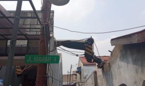 Sebuah crane jatuh dan menimpa rumah warga di Jalan Jalan Mawar Raya, Depok Jaya, pada Jumat (15/10). (Istimewa)