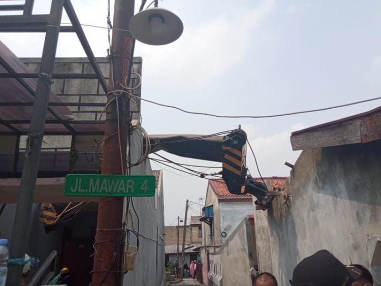 Sebuah crane jatuh dan menimpa rumah warga di Jalan Jalan Mawar Raya, Depok Jaya, pada Jumat (15/10). (Istimewa)