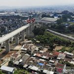 Kereta api melintas di dekat proyek konstruksi kereta api cepat Jakarta-Bandung di Lembah Teratai, Kabupaten Bandung Barat, Jawa Barat, Minggu (8/8/2021). Gubernur Jawa Barat Ridwan Kamil menyatakan uji coba kereta cepat Jakarta-Bandung ditargetkan akan dilaksanakan pada Oktober 2022 mendatang sementara pada Januari 2022, seluruh konstruksi beton proyek tersebut sudah tersambung sepenuhnya. (ANTARA FOTO/Raisan Al Farisi)