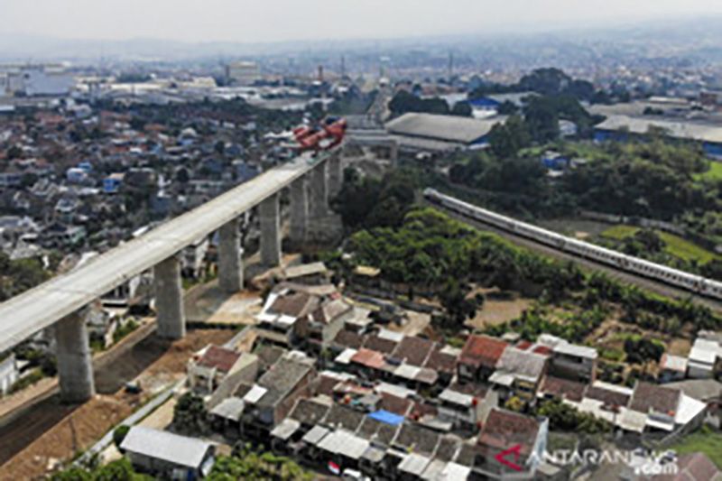 Kereta api melintas di dekat proyek konstruksi kereta api cepat Jakarta-Bandung di Lembah Teratai, Kabupaten Bandung Barat, Jawa Barat, Minggu (8/8/2021). Gubernur Jawa Barat Ridwan Kamil menyatakan uji coba kereta cepat Jakarta-Bandung ditargetkan akan dilaksanakan pada Oktober 2022 mendatang sementara pada Januari 2022, seluruh konstruksi beton proyek tersebut sudah tersambung sepenuhnya. (ANTARA FOTO/Raisan Al Farisi)