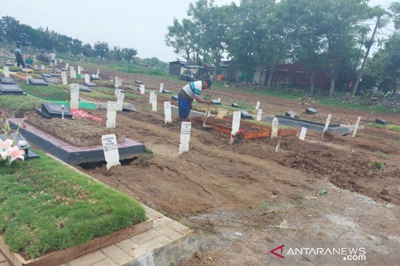 Pengurus TPU Mangunjaya Tambun, Kabupaten Bekasi, Jawa Barat memadatkan tanah makam amblas dengan menambah volume tanah. (ANTARA/Pradita Kurniawan Syah).