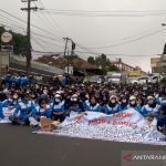 Ribuan buruh menggelar aksi duduk di Jalan Raya Cipanas-Cianjur, Jawa Barat, setelah dihadang petugas untuk menggelar aksi didepan Istana Cipanas, Cianjur, Jawa Barat, Selasa (23/11). ANTARA FOTO/Ahmad Fikri