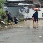 Warga Desa Cikuya, Kecamatan Cicalengka, Kabupaten Bandung (ujung kiri) saat membersihkan sumbatan saluran air karena sampah. (Jabar Ekspres)